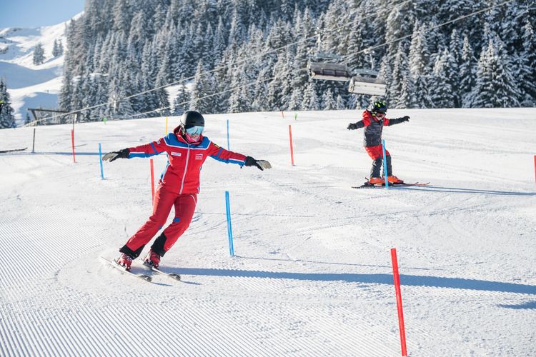Fortgeschrittene Kinder mit Skilehrer auf der Piste Skischule Maria Alm