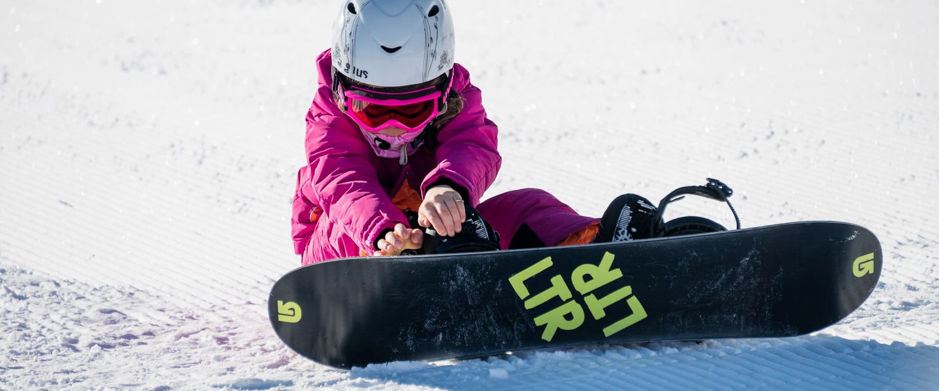 Kleinkind beim Snowboarden Skischule Maria Alm